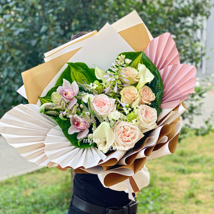 Пышный букет кремовых роз и зелени (в руках флориста)